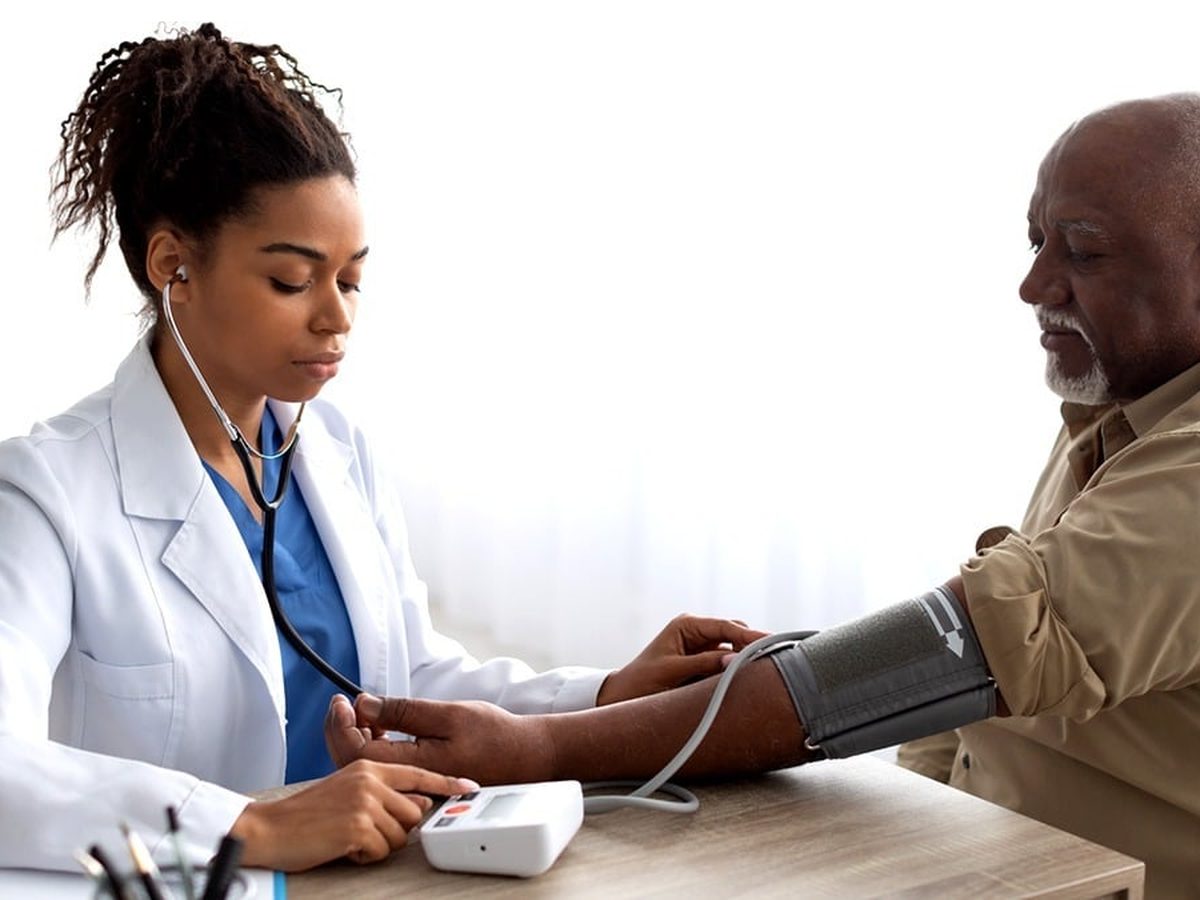 A health worker taking a patient’s blood pressure